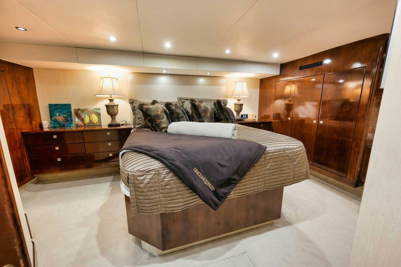 a bedroom with a bed and a dresser aboard UNCONQUERED Yacht for Sale