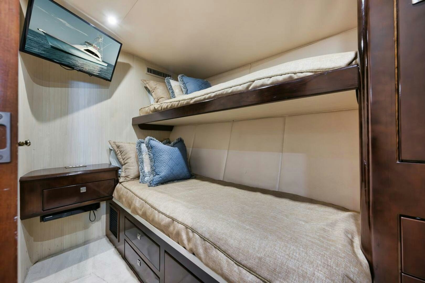 a bed with a wooden headboard aboard UNCONQUERED Yacht for Sale