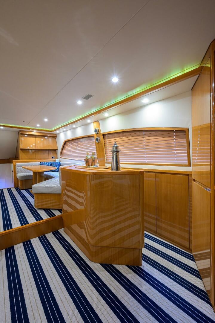 a room with a wood desk and a glass bottle on the table aboard GOIN DEEP Yacht for Sale