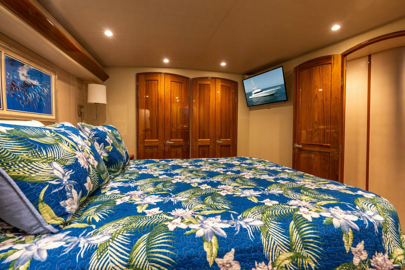 a bedroom with a bed and a television on the wall aboard NO COLLARS Yacht for Sale