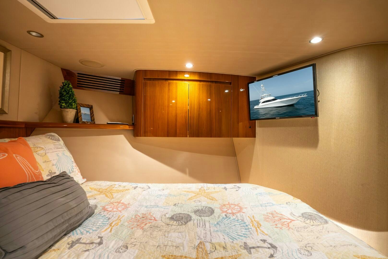 a bed with a television on the wall aboard NO COLLARS Yacht for Sale