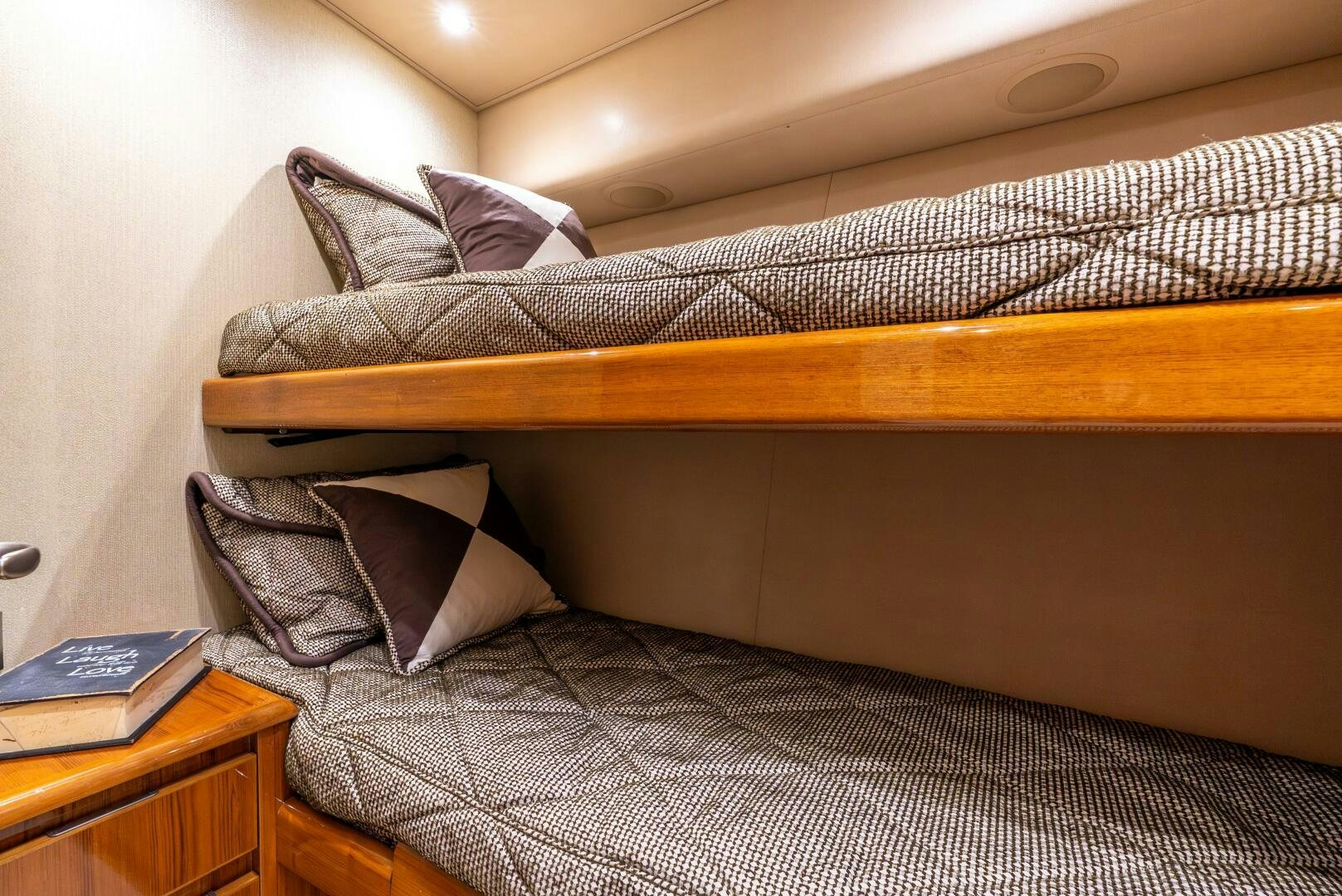 a bed with a pillow and a book on it aboard NO COLLARS Yacht for Sale