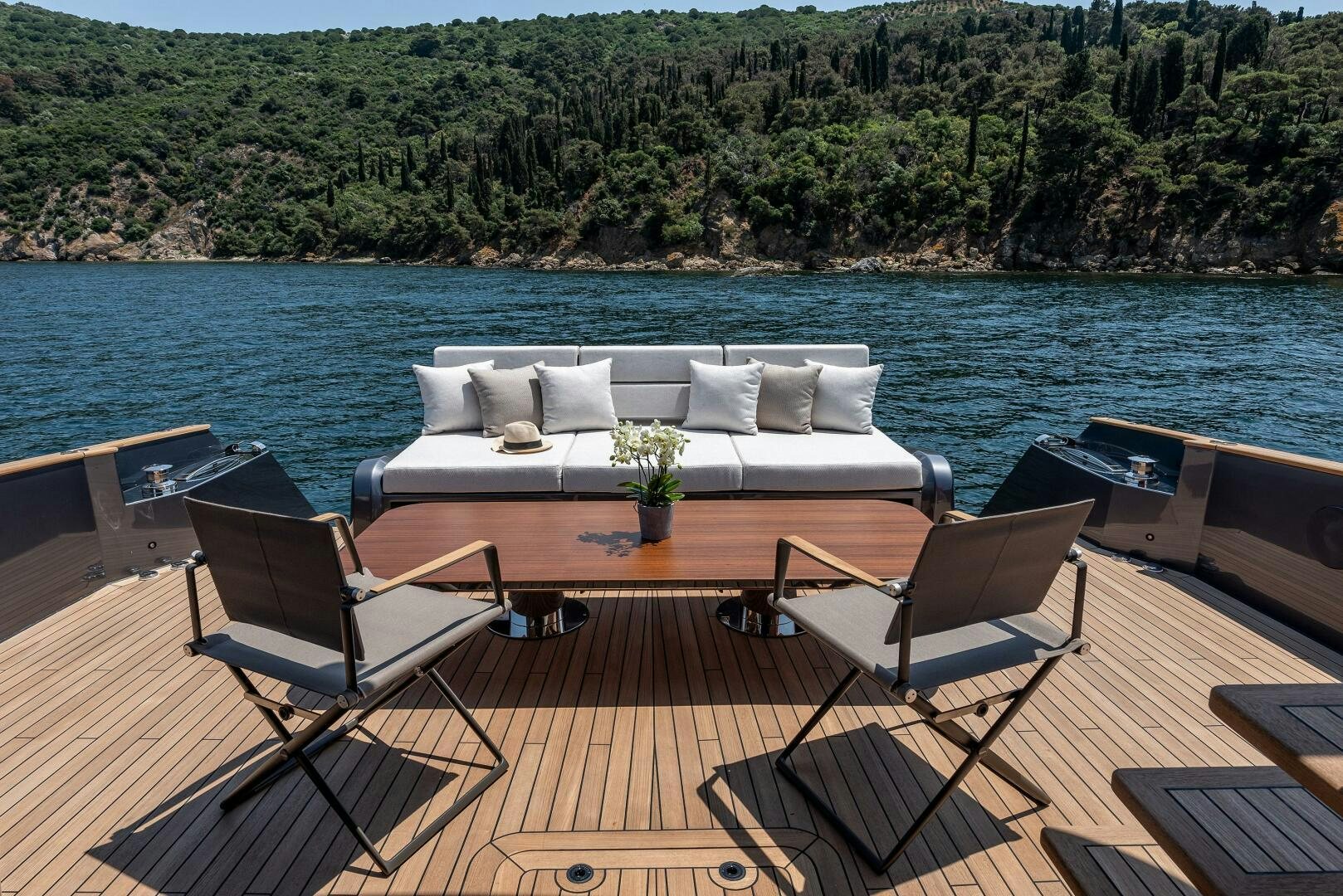 a table and chairs on a deck overlooking a body of water aboard SUNYA Yacht for Sale