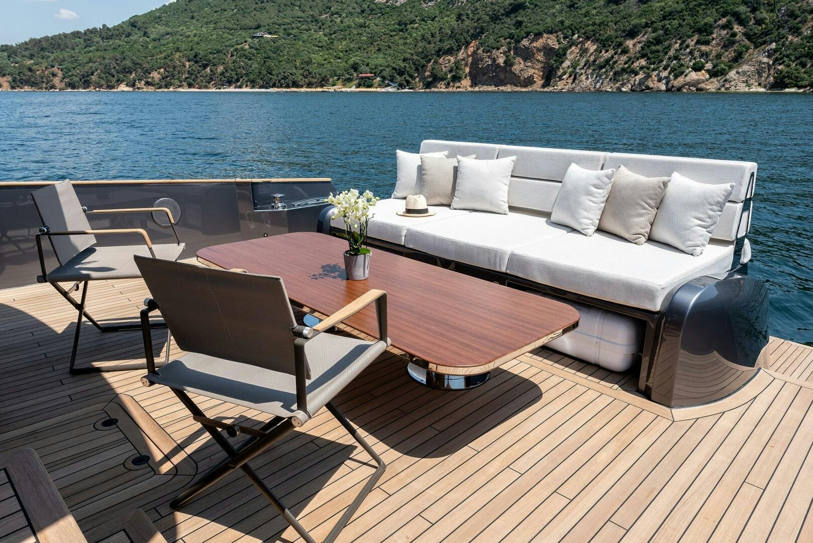 a couch and a table on a deck overlooking a body of water aboard SUNYA Yacht for Sale