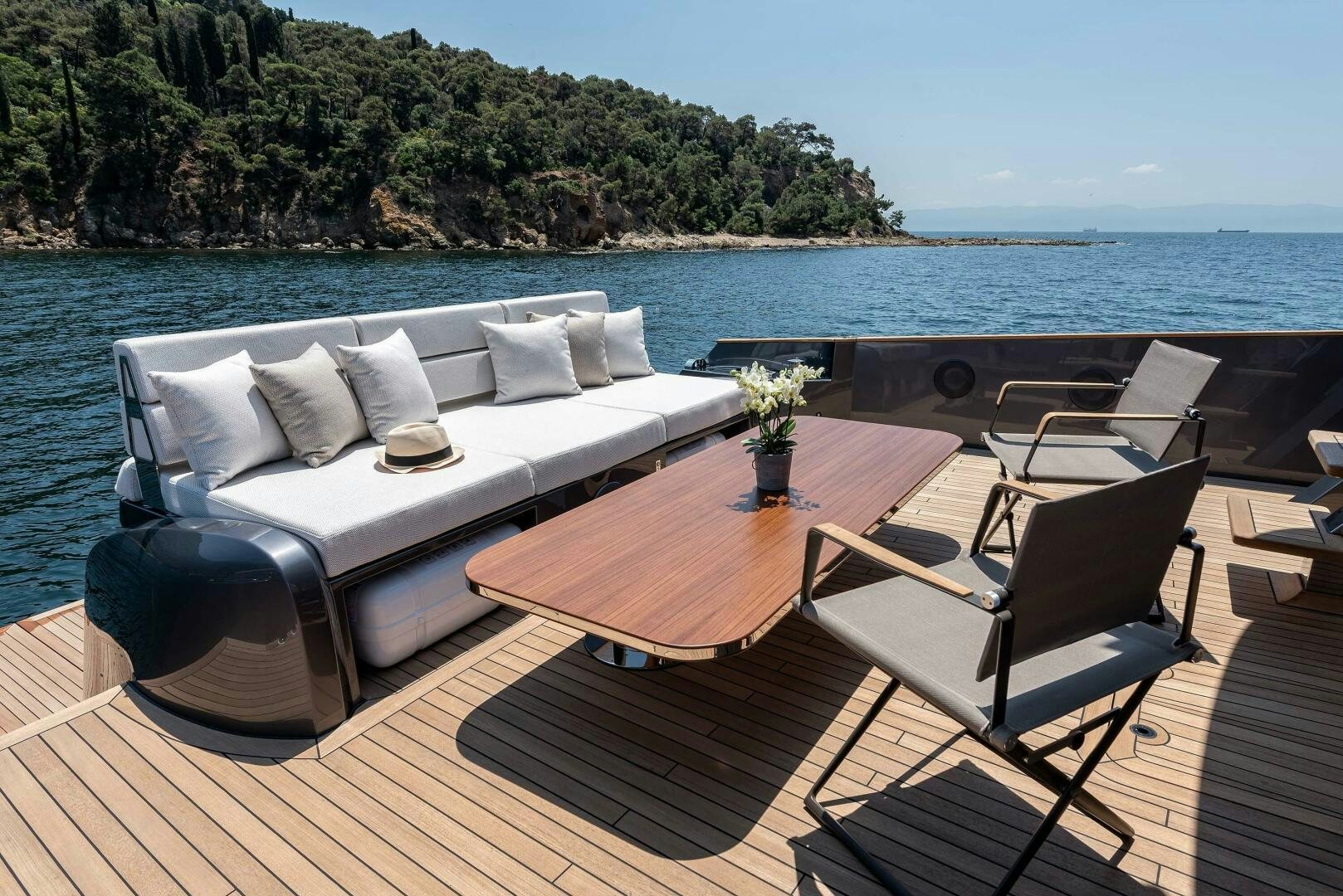 a table and chairs on a deck overlooking a body of water aboard SUNYA Yacht for Sale