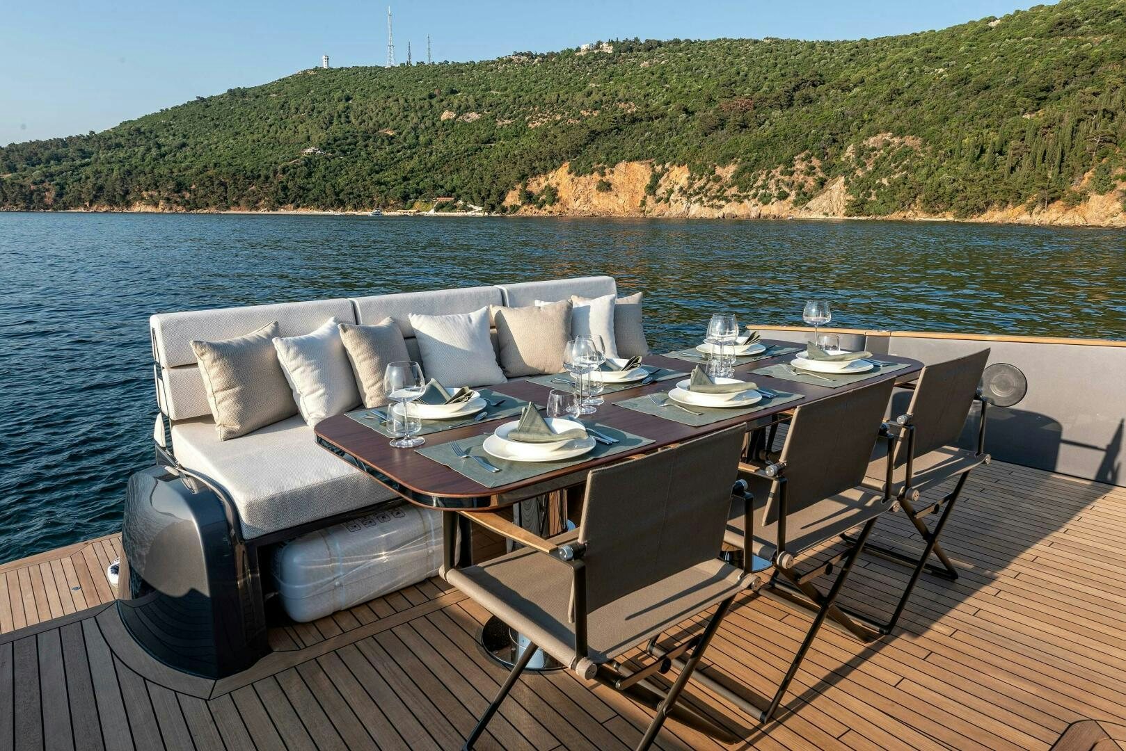 a table set with chairs and a view of a mountain aboard SUNYA Yacht for Sale