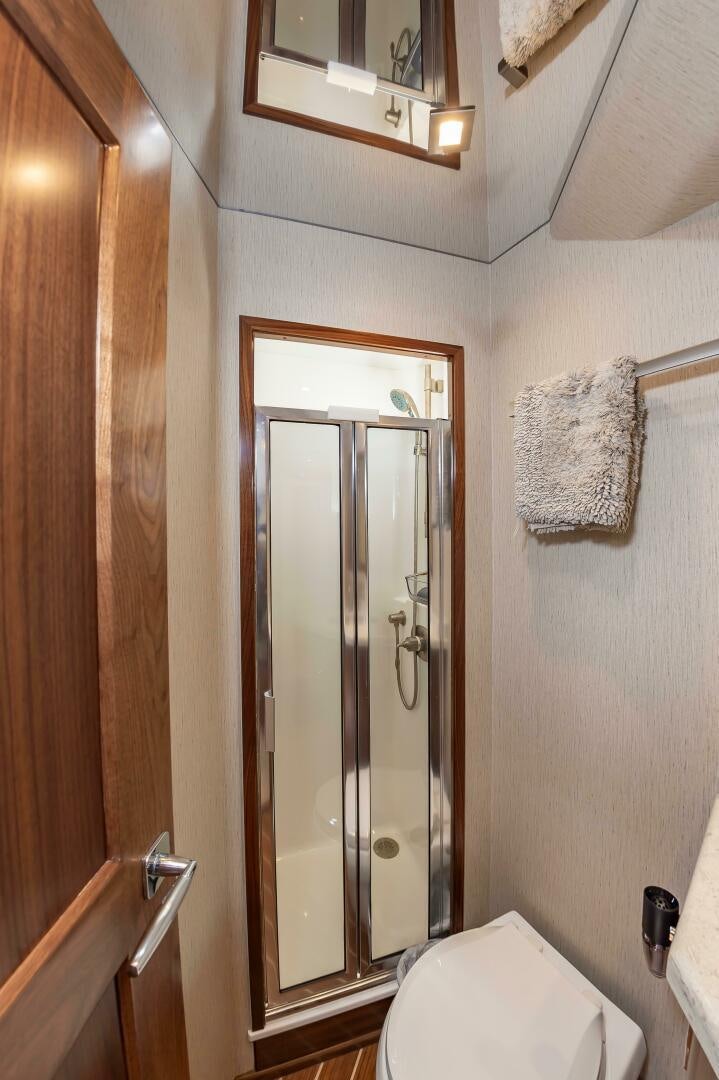 a bathroom with a glass shower door aboard KNOT DONE YET Yacht for Sale