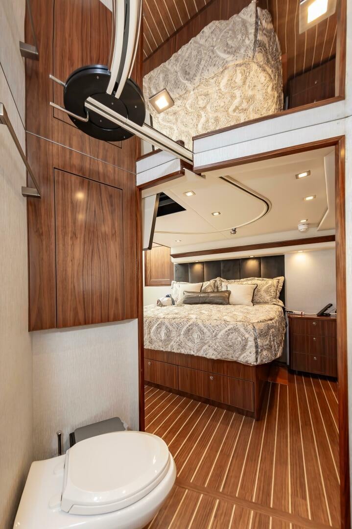 a bedroom with a bed and a wood cabinet aboard KNOT DONE YET Yacht for Sale