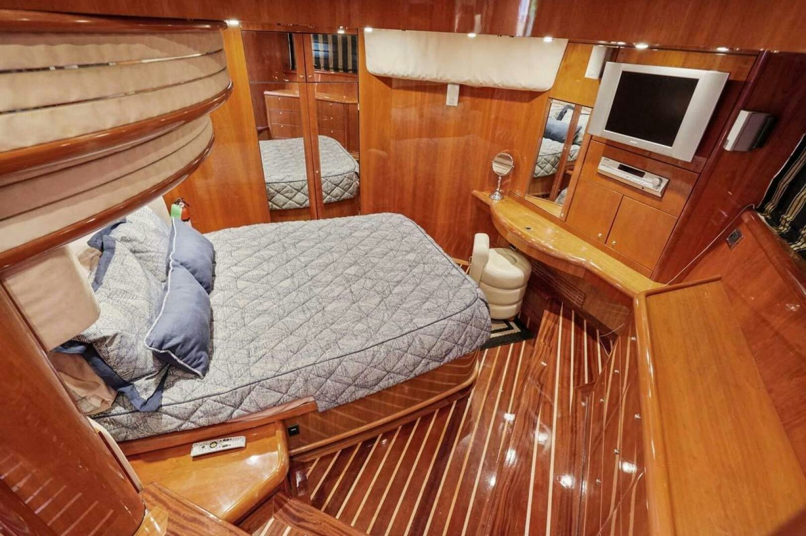 a bedroom with a bed and a television aboard OBSESSION Yacht for Sale