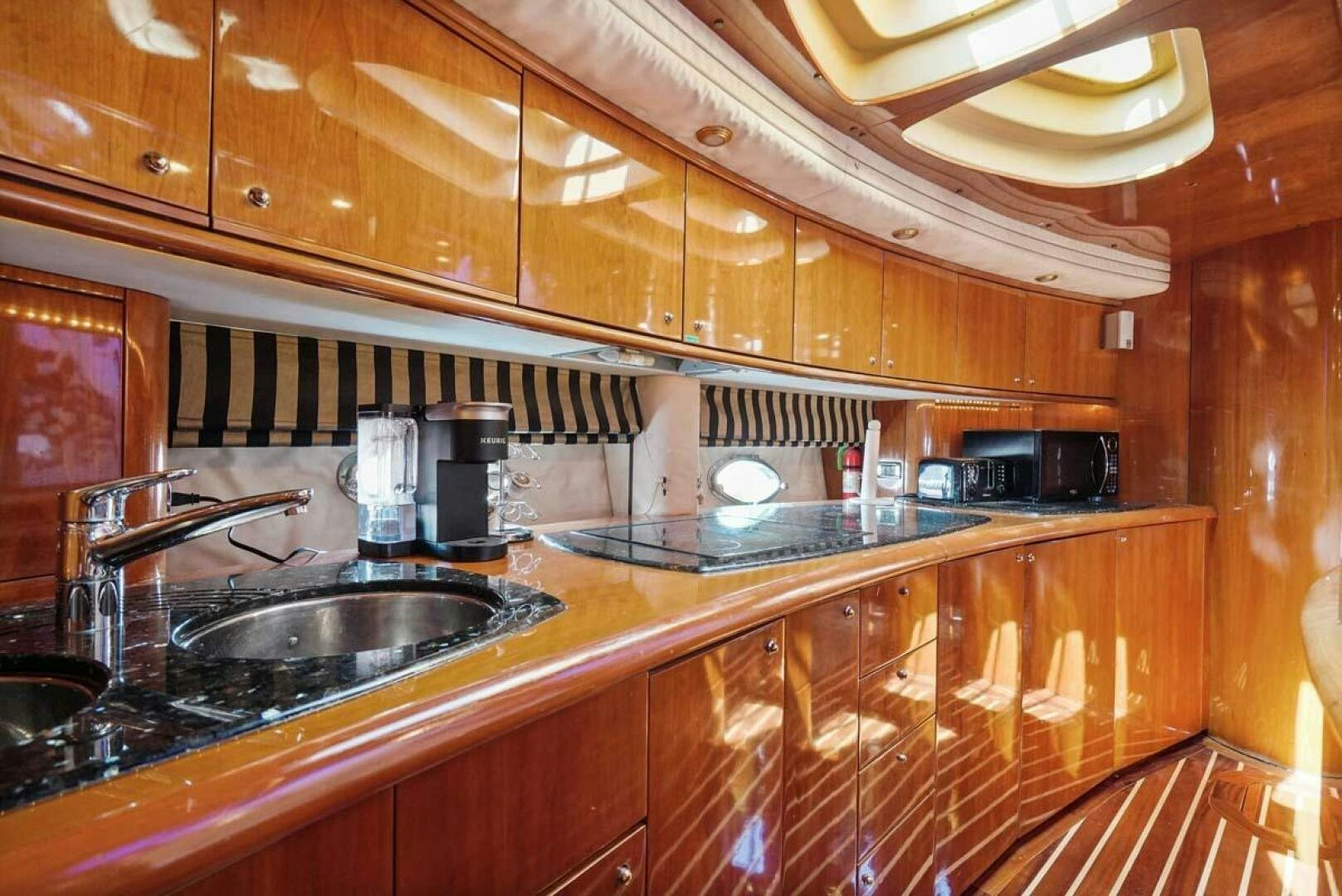 a kitchen with wooden cabinets aboard OBSESSION Yacht for Sale
