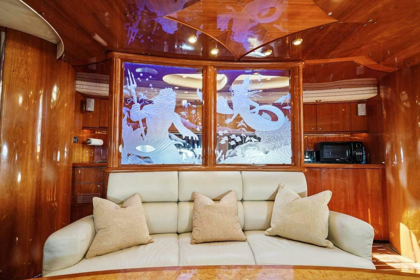 a couch with a tv on the wall aboard OBSESSION Yacht for Sale