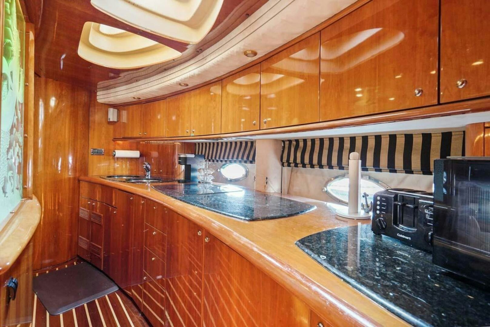 a kitchen with wooden cabinets aboard OBSESSION Yacht for Sale