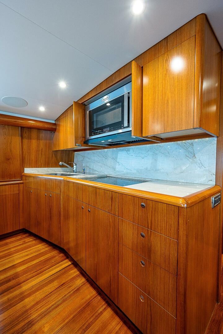 a kitchen with wooden cabinets aboard MAXIMUS Yacht for Sale