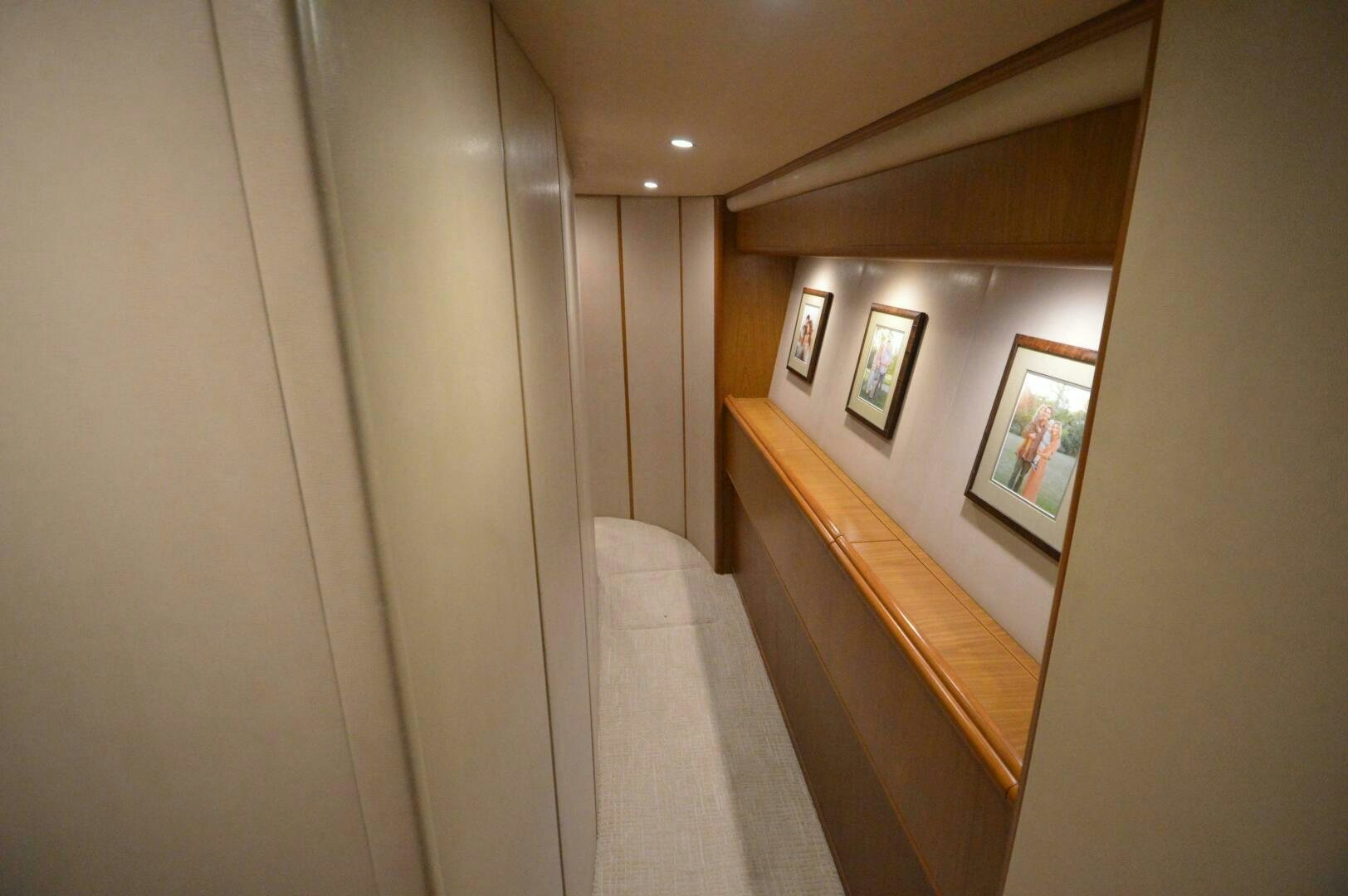 a hallway with a staircase and pictures on the wall aboard LOW PROFILE Yacht for Sale