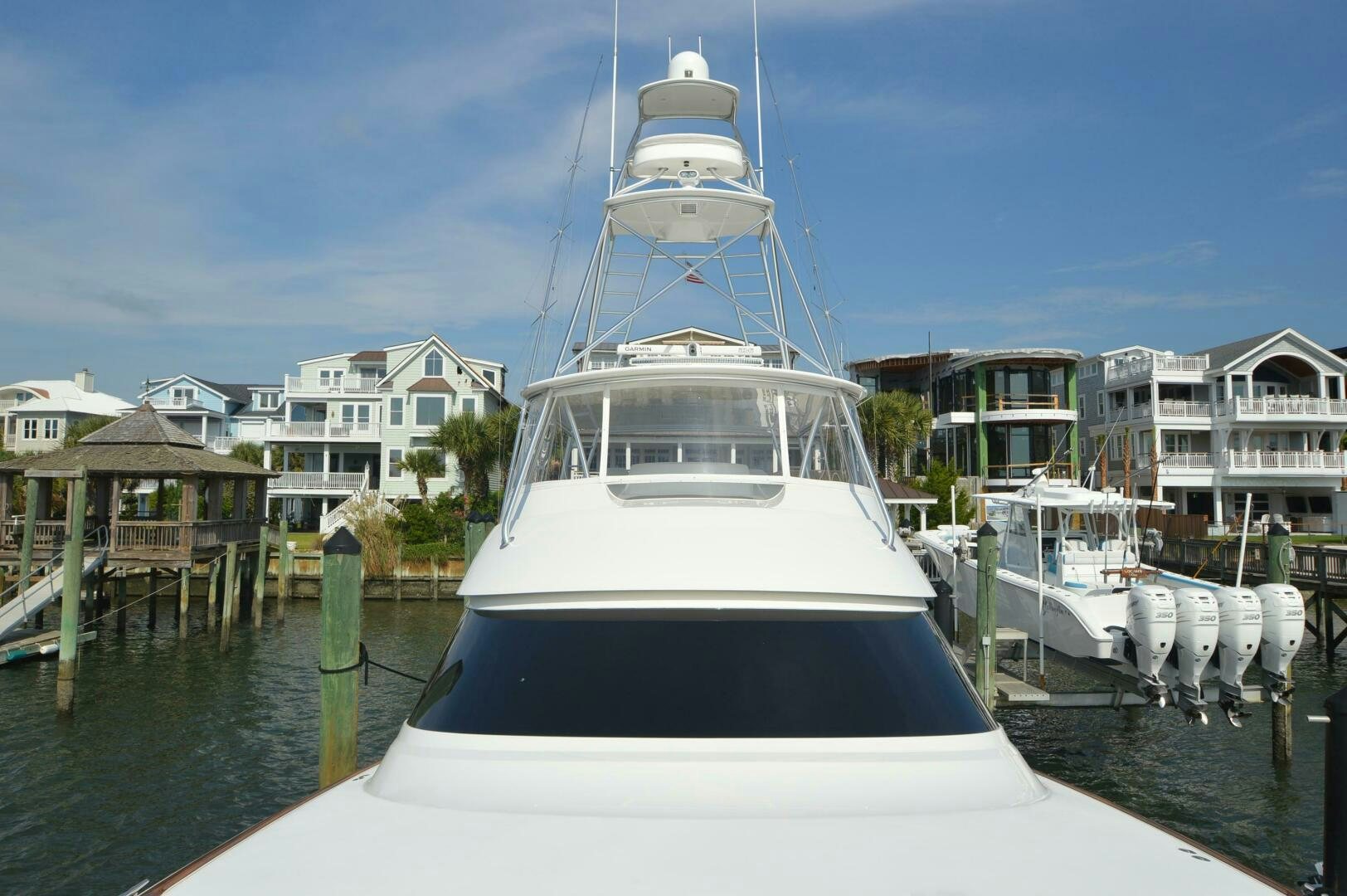 a white boat in a harbor aboard LOW PROFILE Yacht for Sale