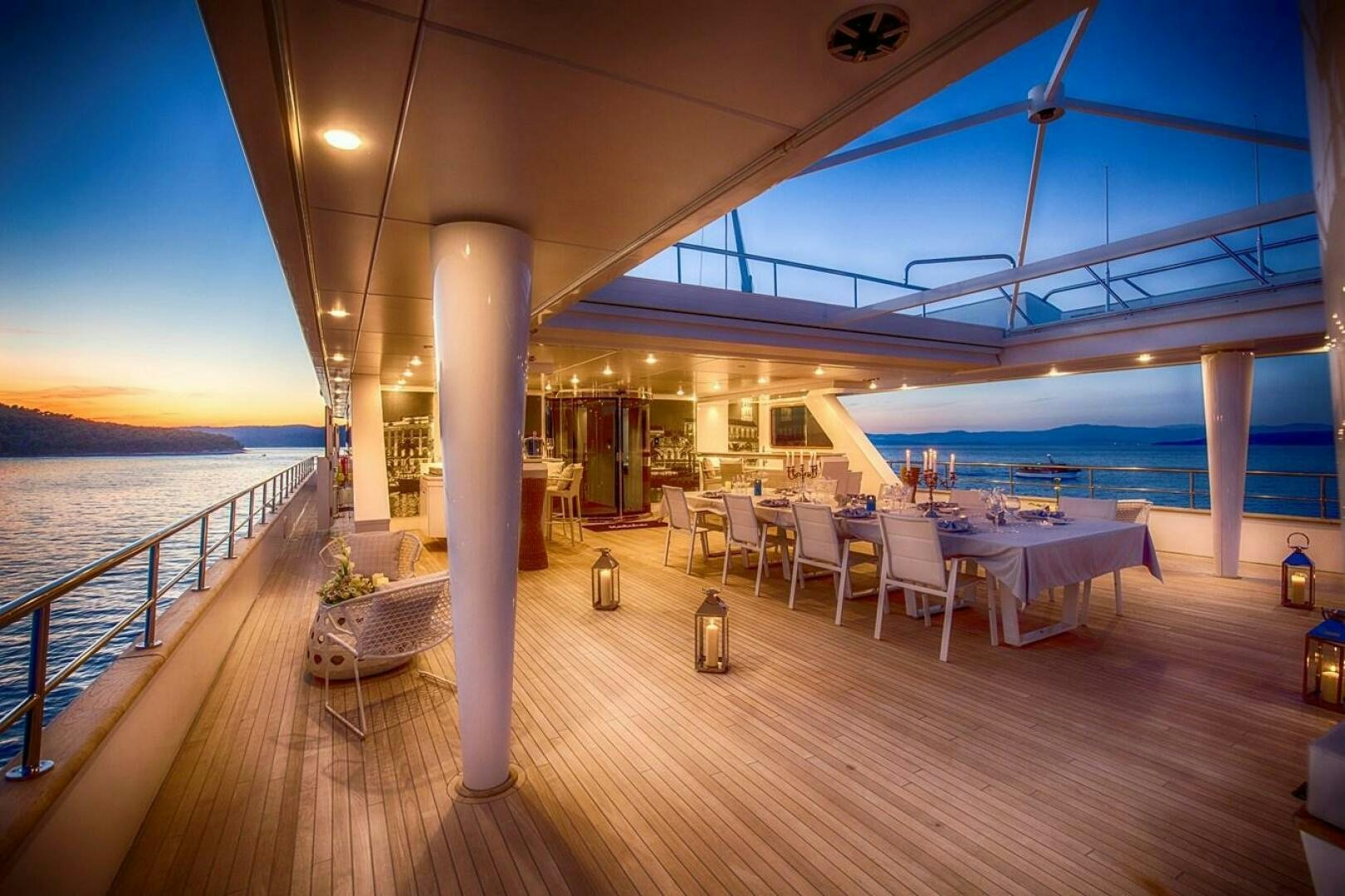 a deck with tables and chairs aboard KATINA Yacht for Sale