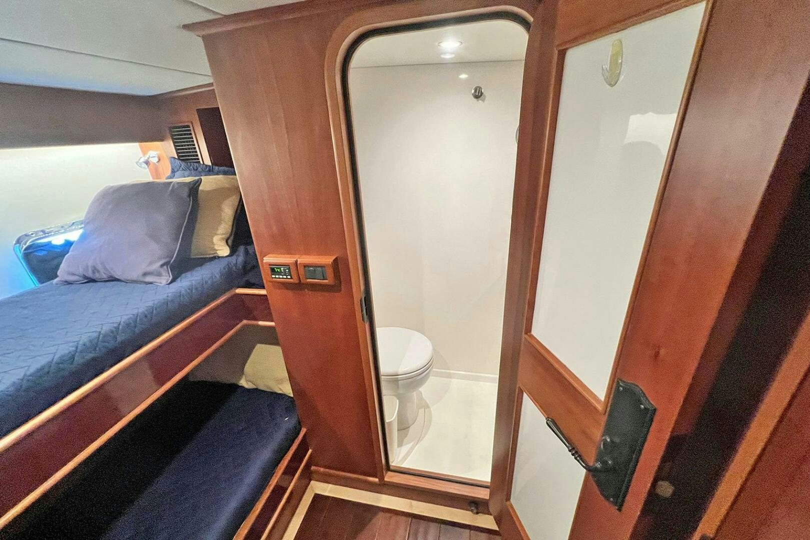 a room with a bed and a mirror aboard INSIGNIA Yacht for Sale