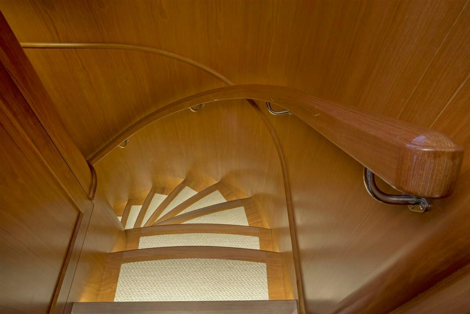 a wooden staircase with a metal railing aboard INSIGNIA Yacht for Sale