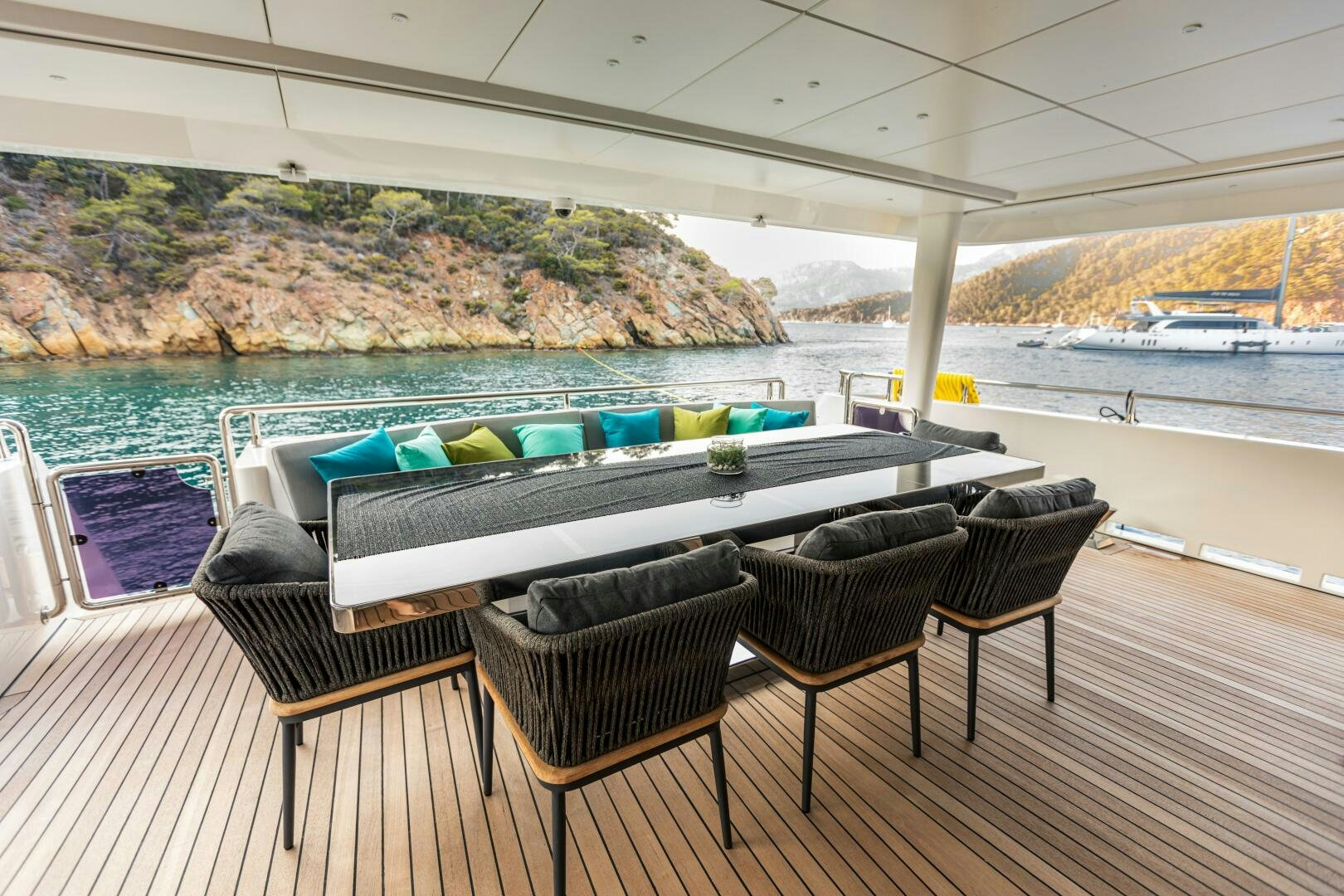 a table and chairs on a deck overlooking a body of water aboard ZEEMAR Yacht for Sale
