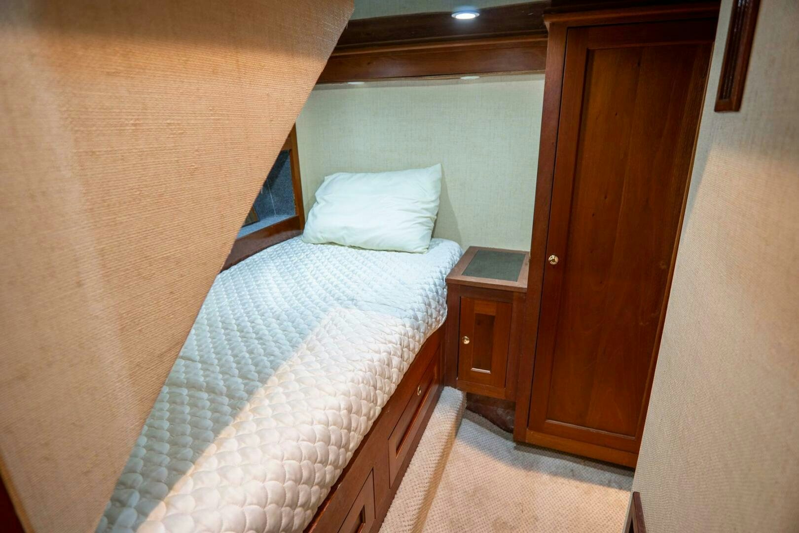 a bed with a white comforter aboard BIG BLUE Yacht for Sale