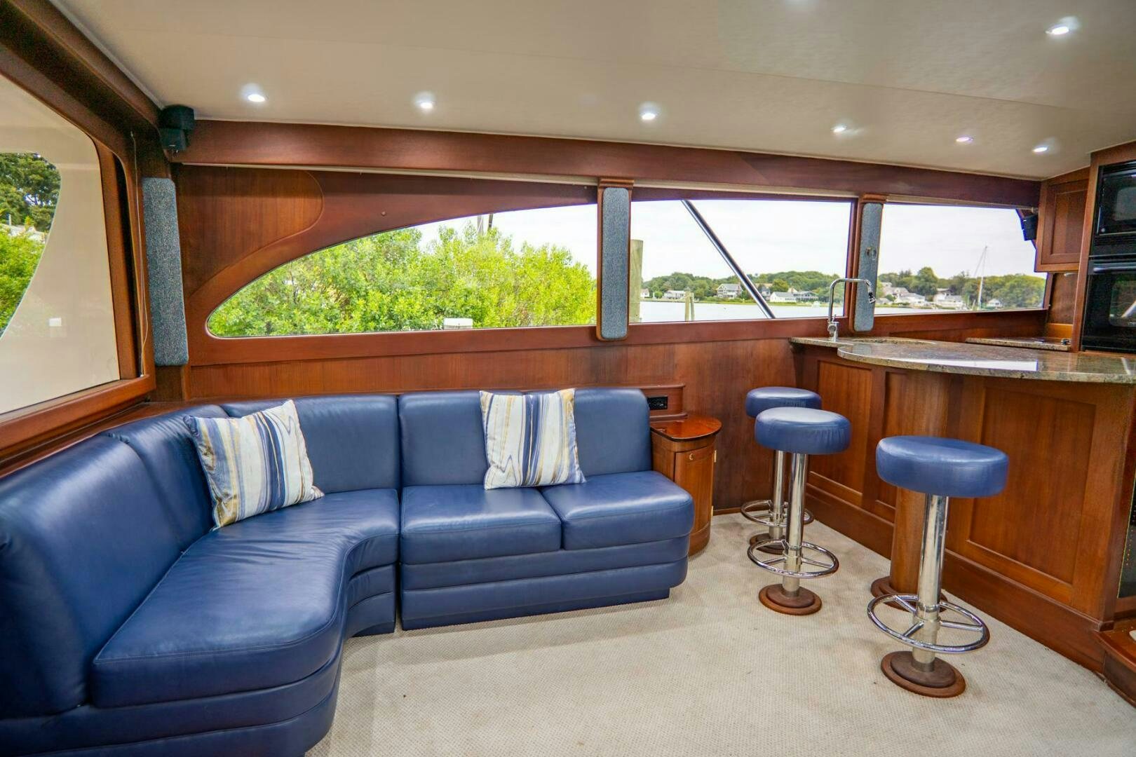 a living room with a couch and stools aboard BIG BLUE Yacht for Sale