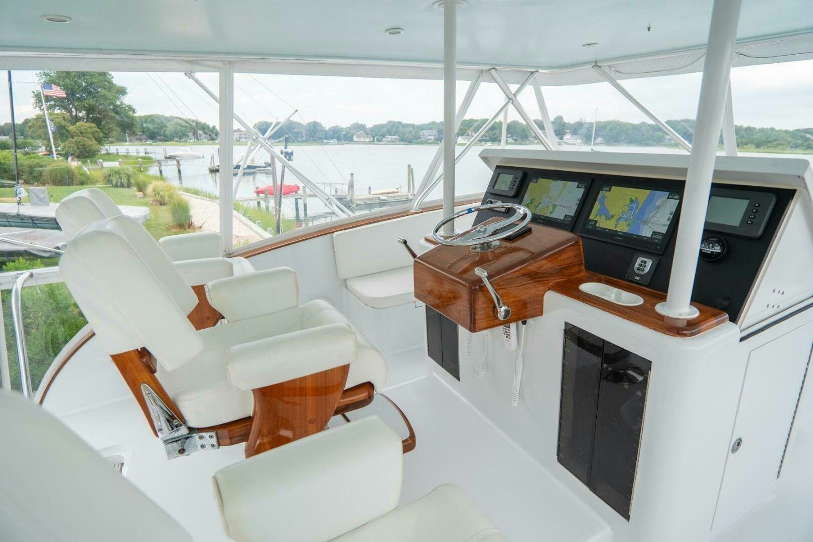 inside of a vehicle with a large screen and a desk with chairs and a computer on it aboard BIG BLUE Yacht for Sale