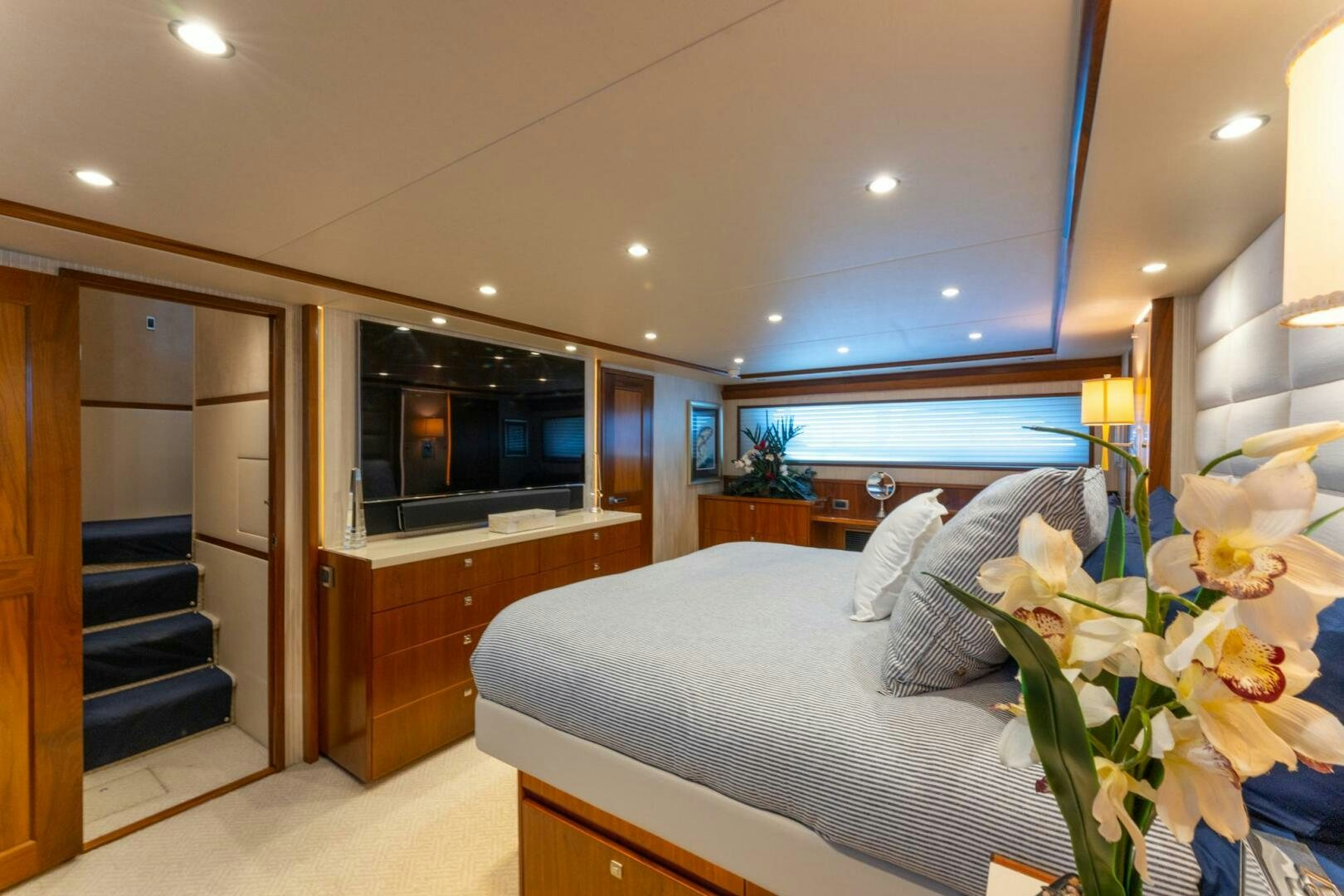 a bedroom with a bed and a television aboard HIGH COTTON Yacht for Sale