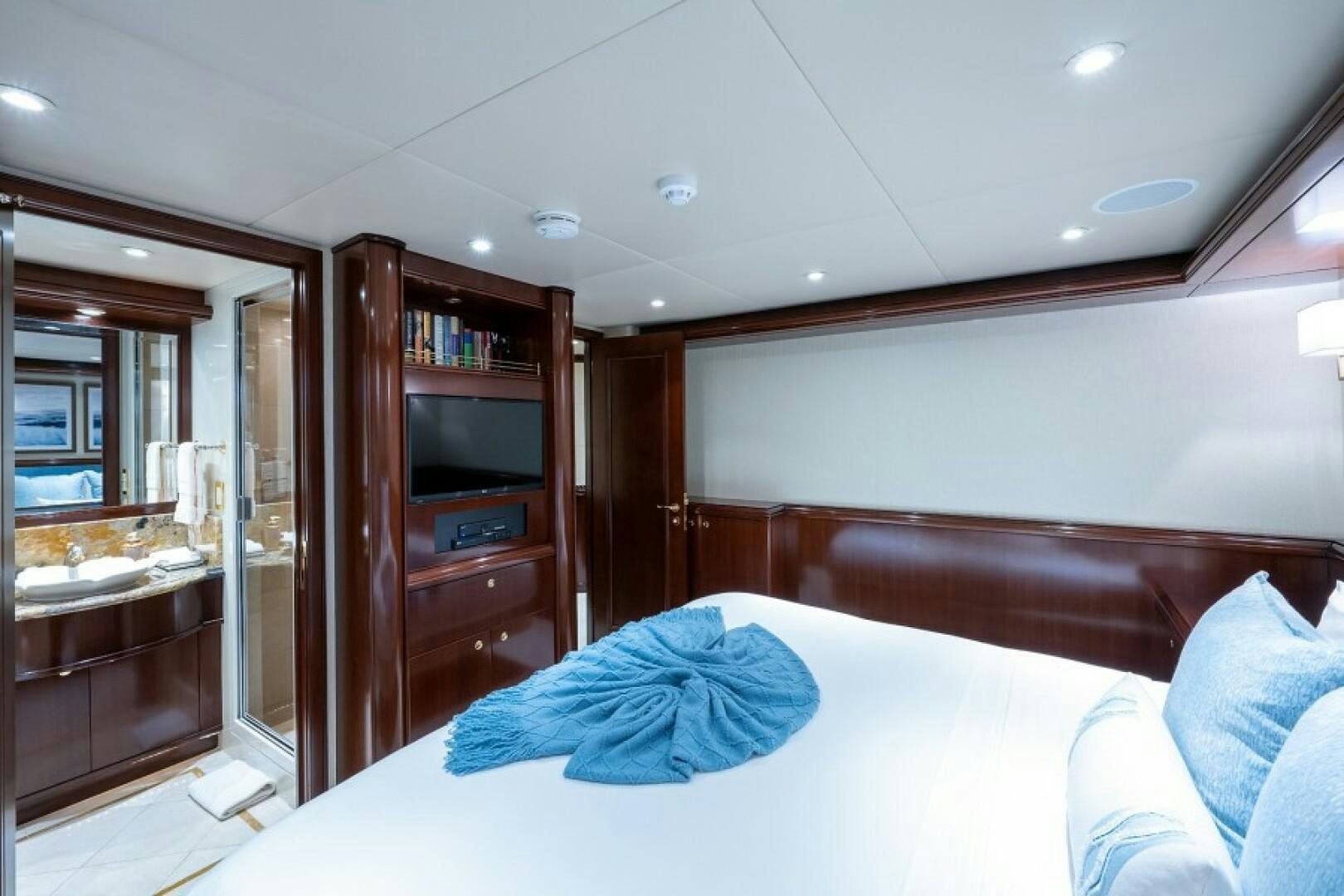 a bedroom with a bed and a television aboard STARSHIP Yacht for Sale