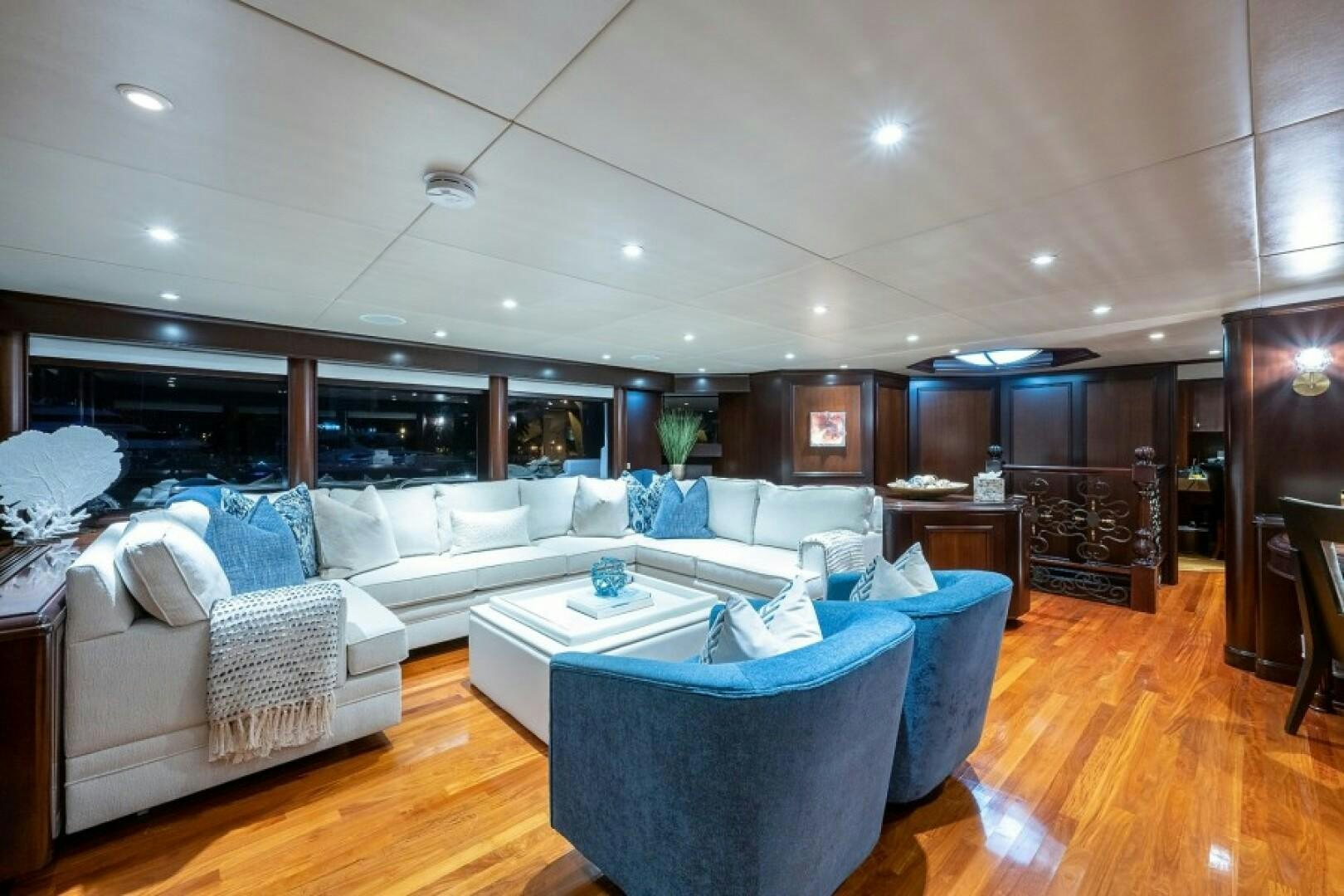 a living room with a large white couch and a wood floor aboard STARSHIP Yacht for Sale
