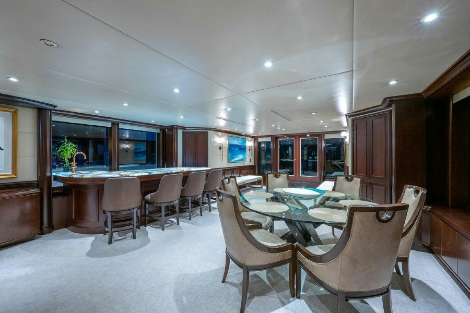 a room with tables and chairs aboard STARSHIP Yacht for Sale
