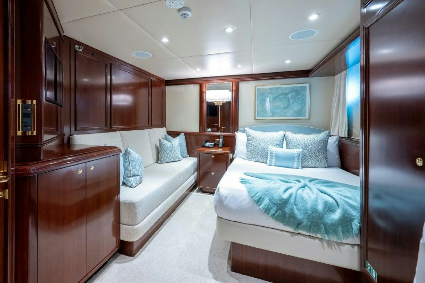 a bedroom with a bed and a desk aboard STARSHIP Yacht for Sale