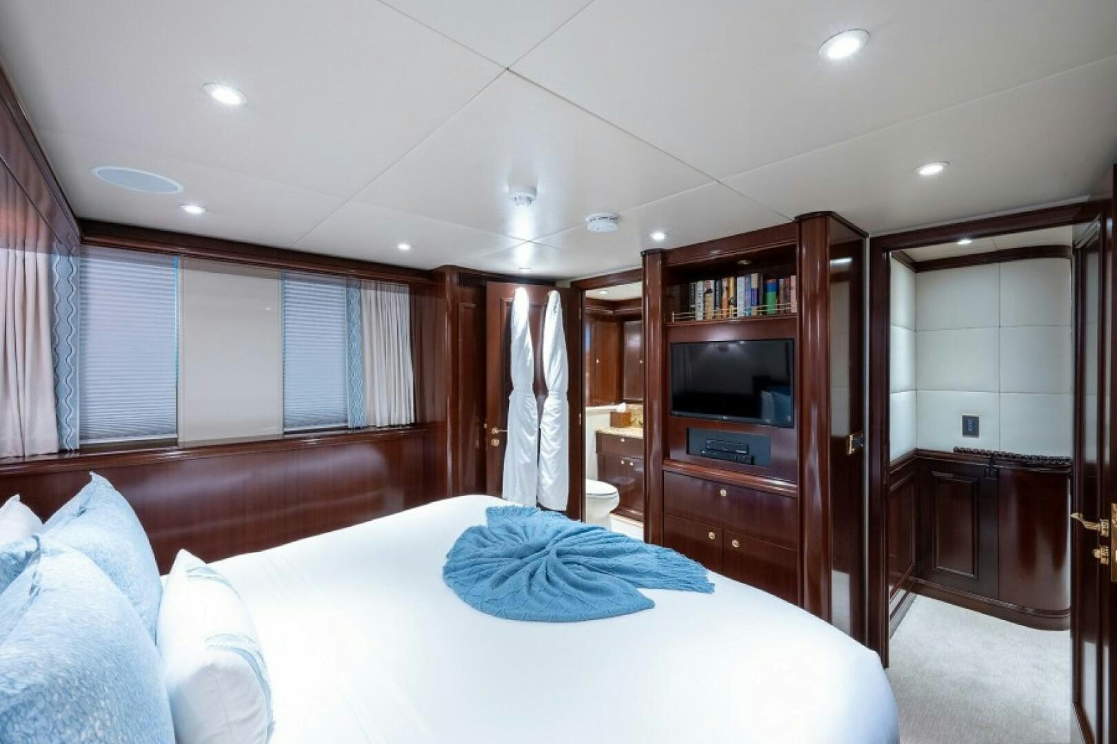 a bedroom with a bed and a television aboard STARSHIP Yacht for Sale