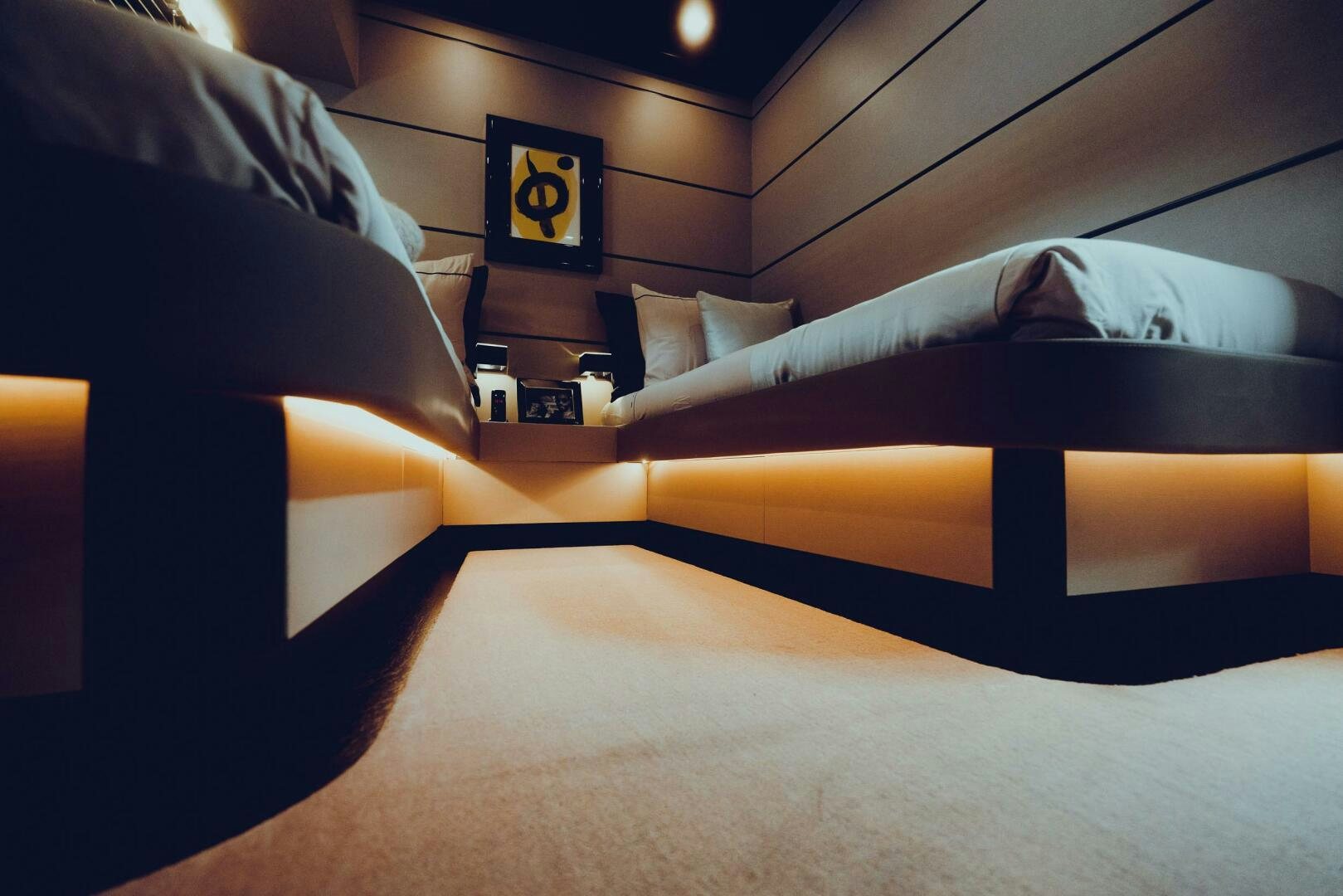 a bed with a black and orange blanket and a black pillow aboard BLACK ROCK Yacht for Sale