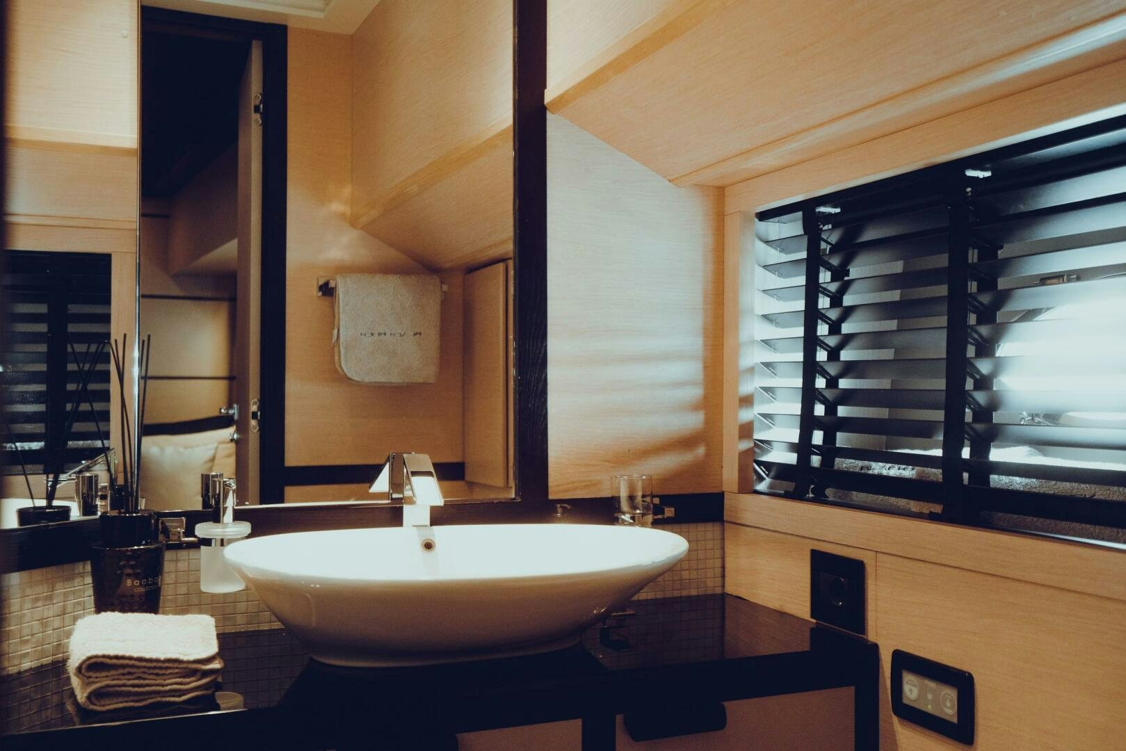 a bathroom with a sink and a large mirror aboard BLACK ROCK Yacht for Sale