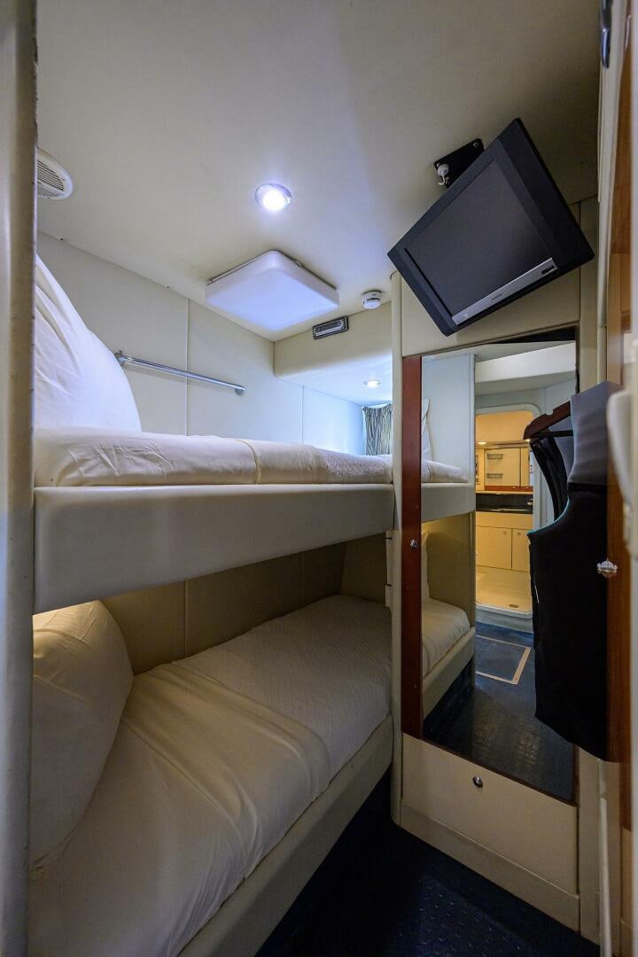 a bed with a tv on the wall aboard THE SHI Yacht for Sale
