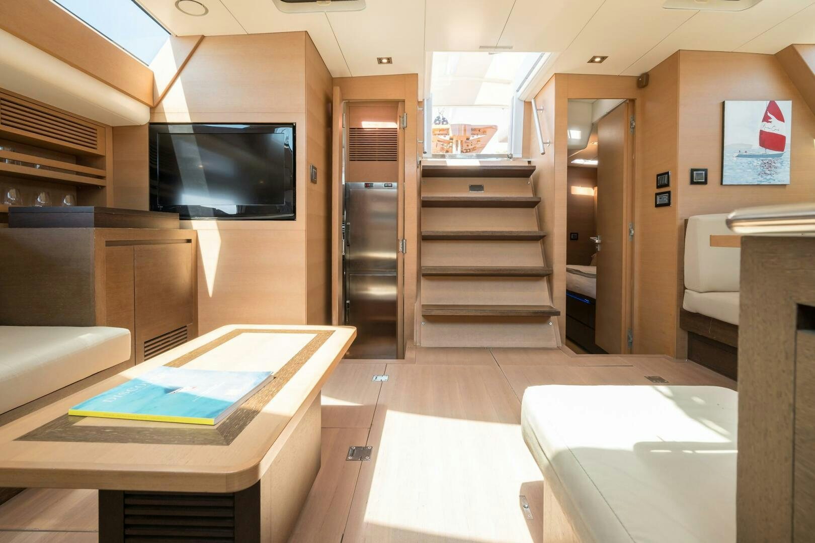 a room with a tv and a table aboard HANNO Yacht for Sale