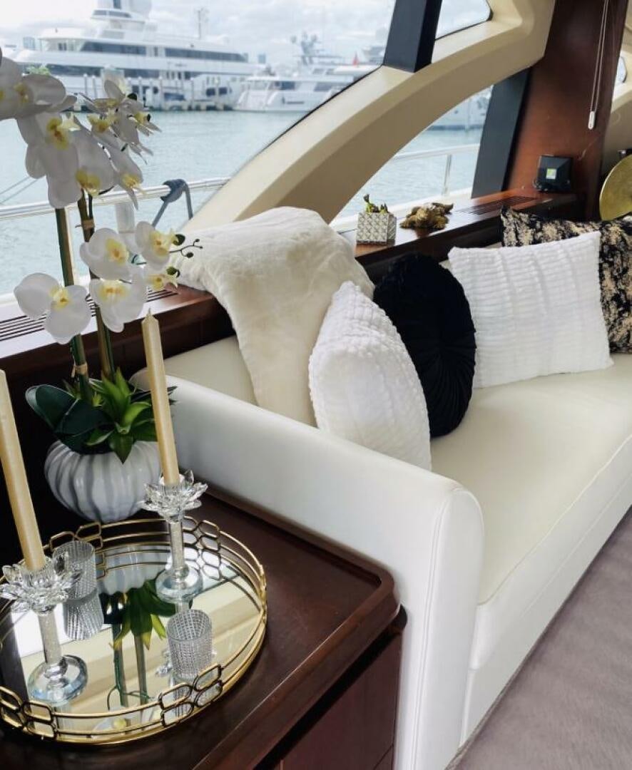 a white couch with white pillows and flowers on it aboard MINIMAL RISK Yacht for Sale
