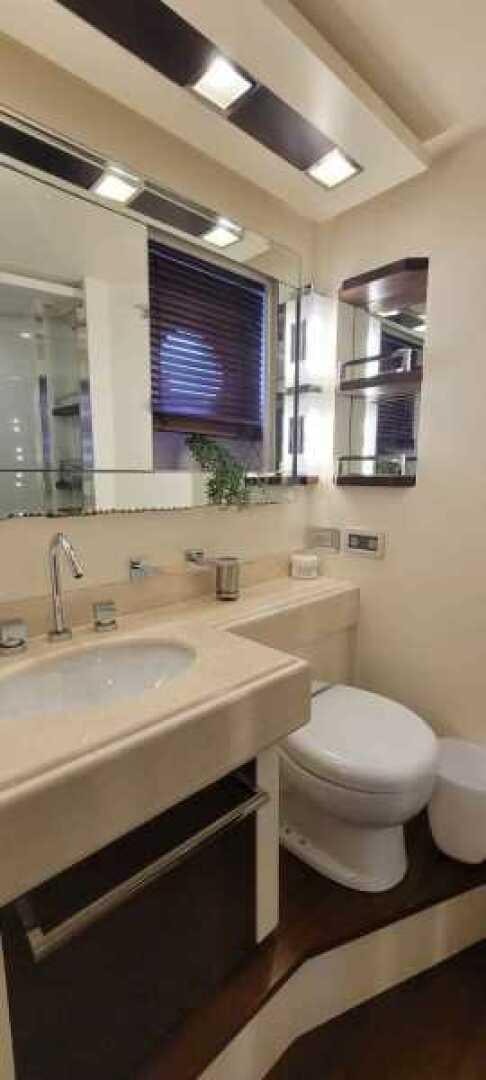 a bathroom with a toilet sink and a mirror aboard MINIMAL RISK Yacht for Sale