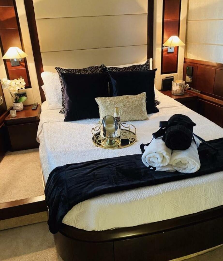 a bed with a blue and white bed spread aboard MINIMAL RISK Yacht for Sale