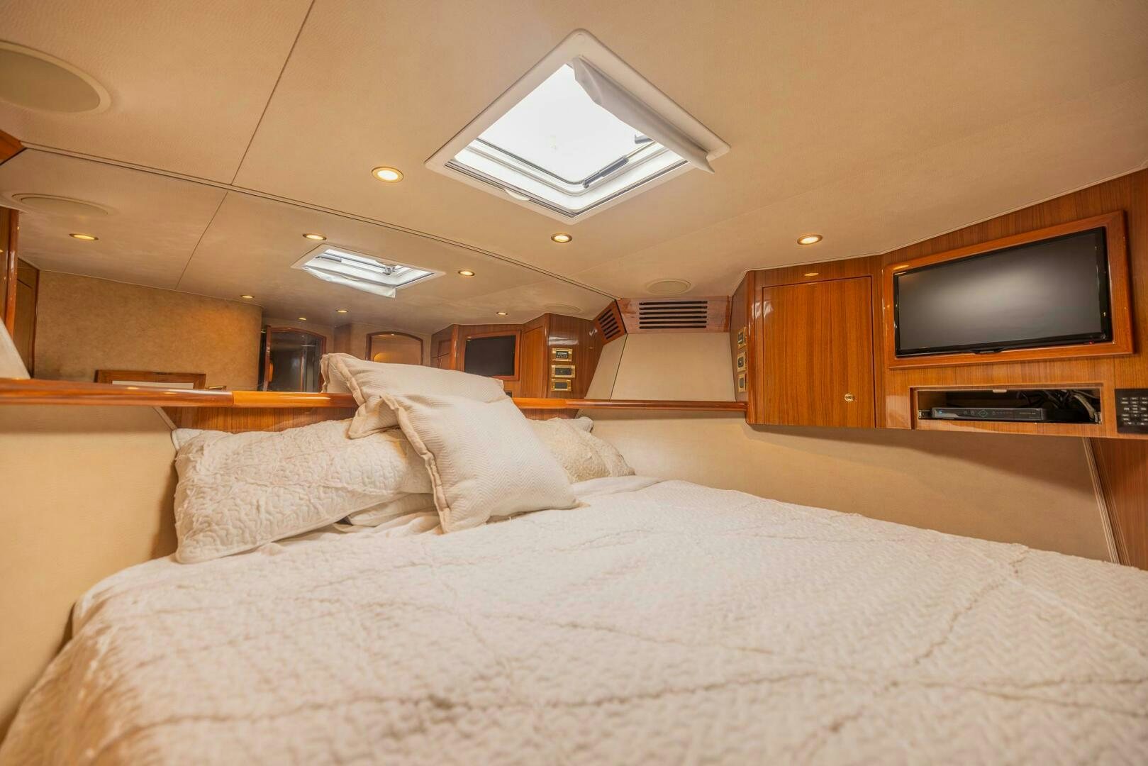 a bed with a television on the wall aboard DON'T STOP BELIEVIN Yacht for Sale