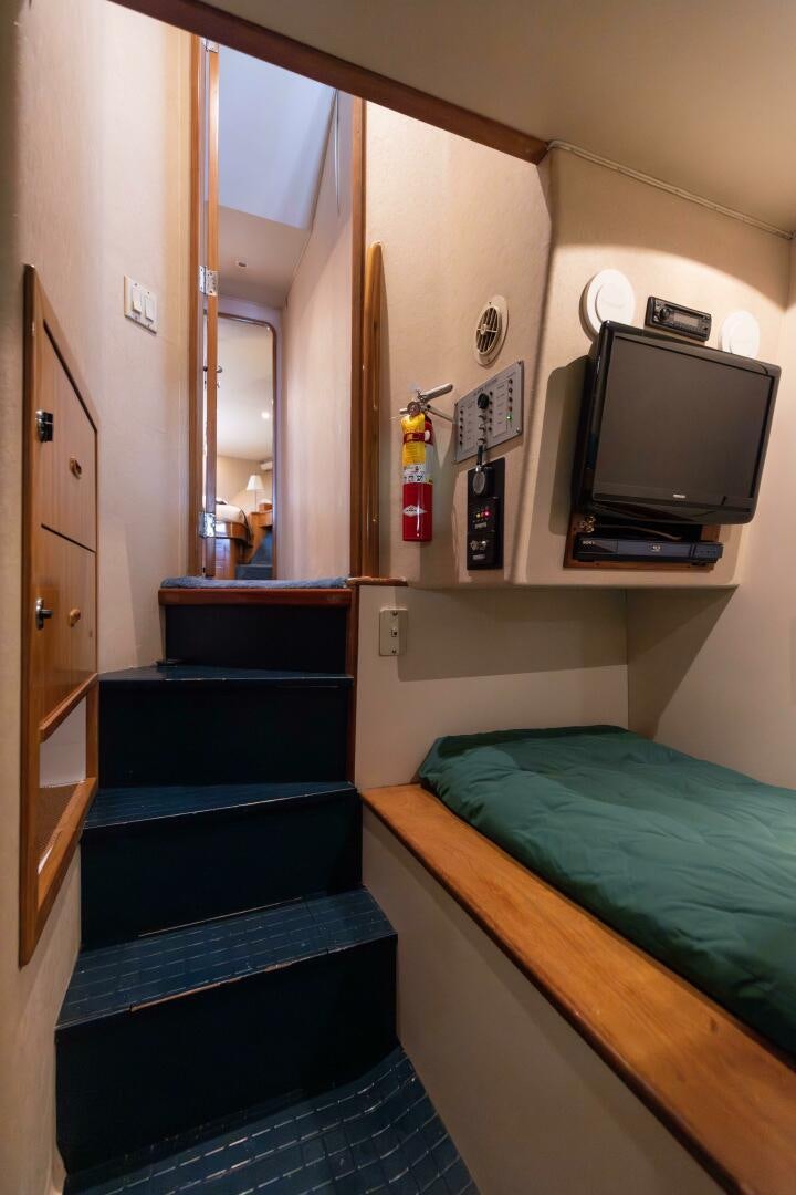 a room with a bed and a television aboard DIXIE Yacht for Sale