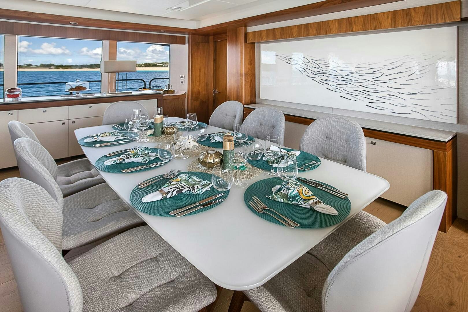 a dining table with plates and glasses aboard EVEREAST Yacht for Sale