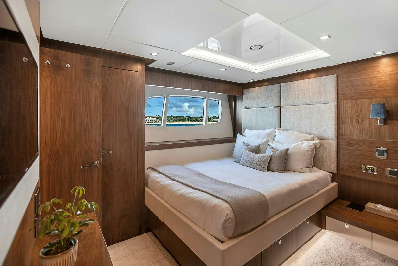 a room with a bed and a wood cabinet aboard EVEREAST Yacht for Sale