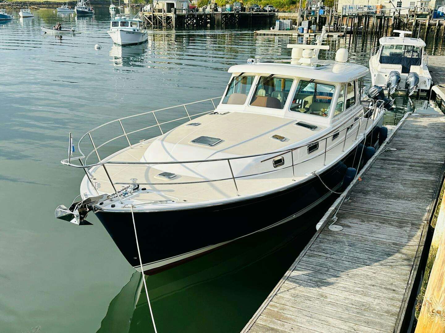 a white boat in a harbor aboard KINSHIP Yacht for Sale