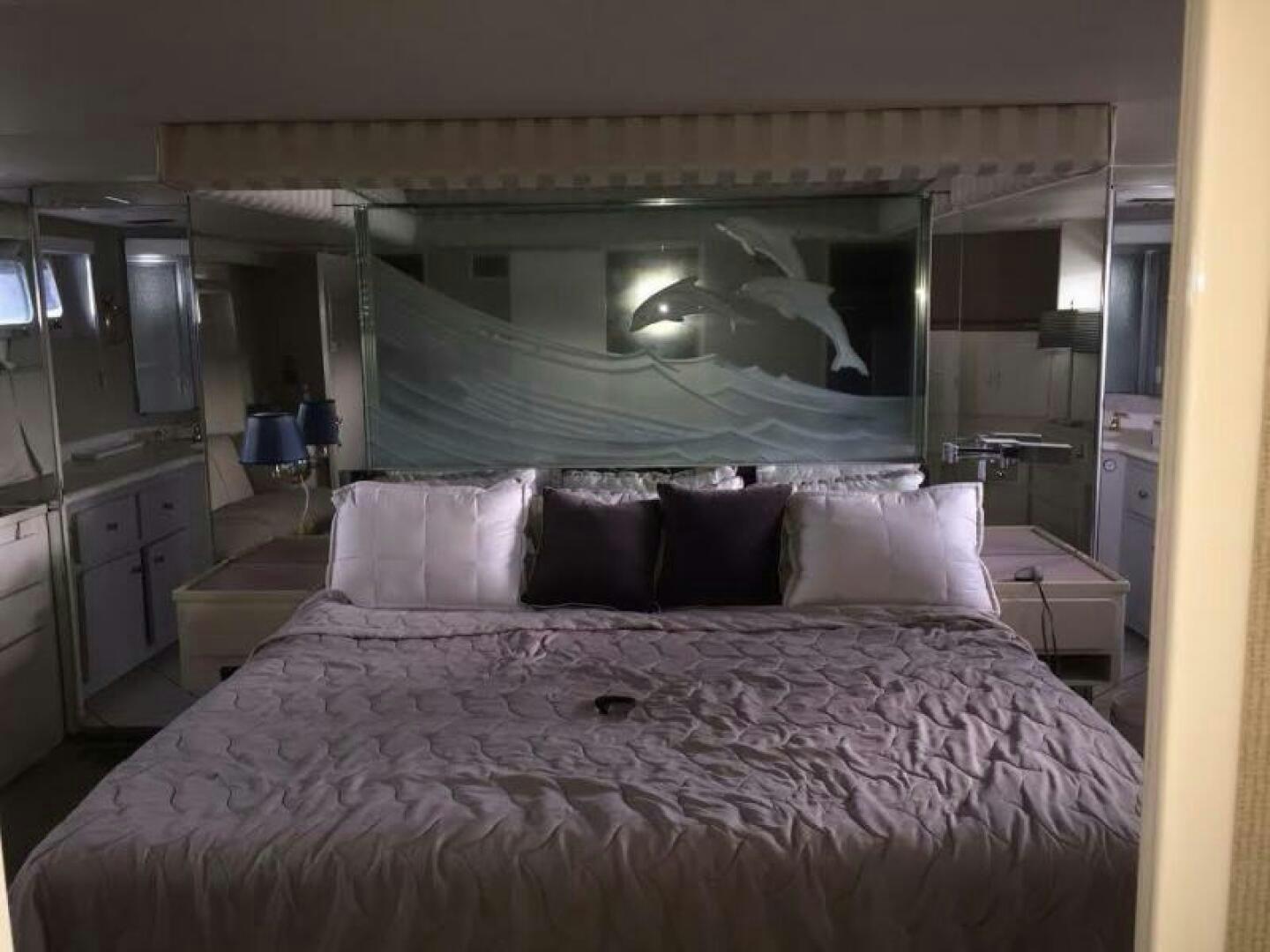 a bed with a large fish painting aboard SOUTHERN BREEZE Yacht for Sale