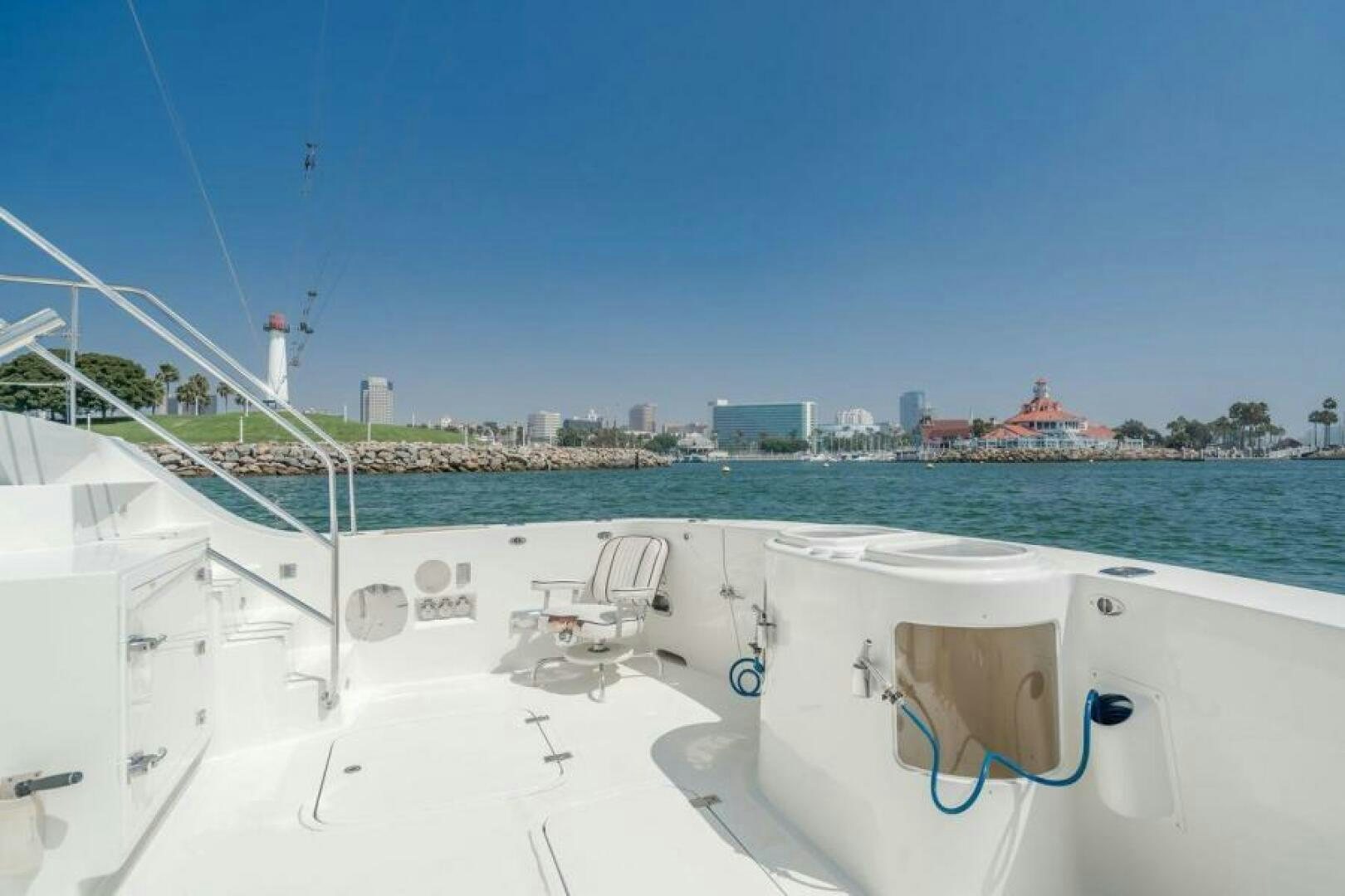 a white boat on a body of water with buildings in the background aboard FAN TAIL I Yacht for Sale
