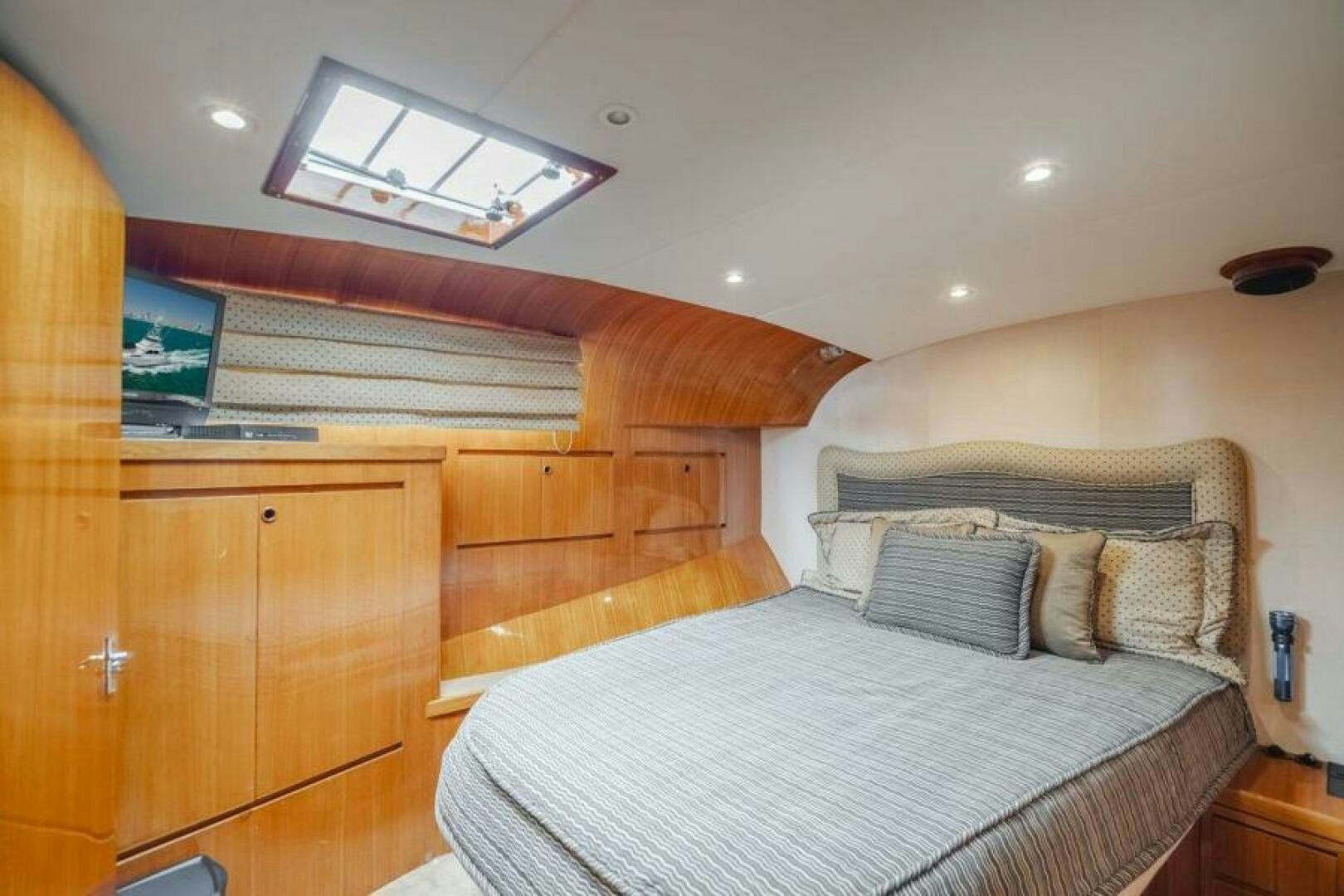 a bedroom with a bed and a wood cabinet aboard FAN TAIL I Yacht for Sale