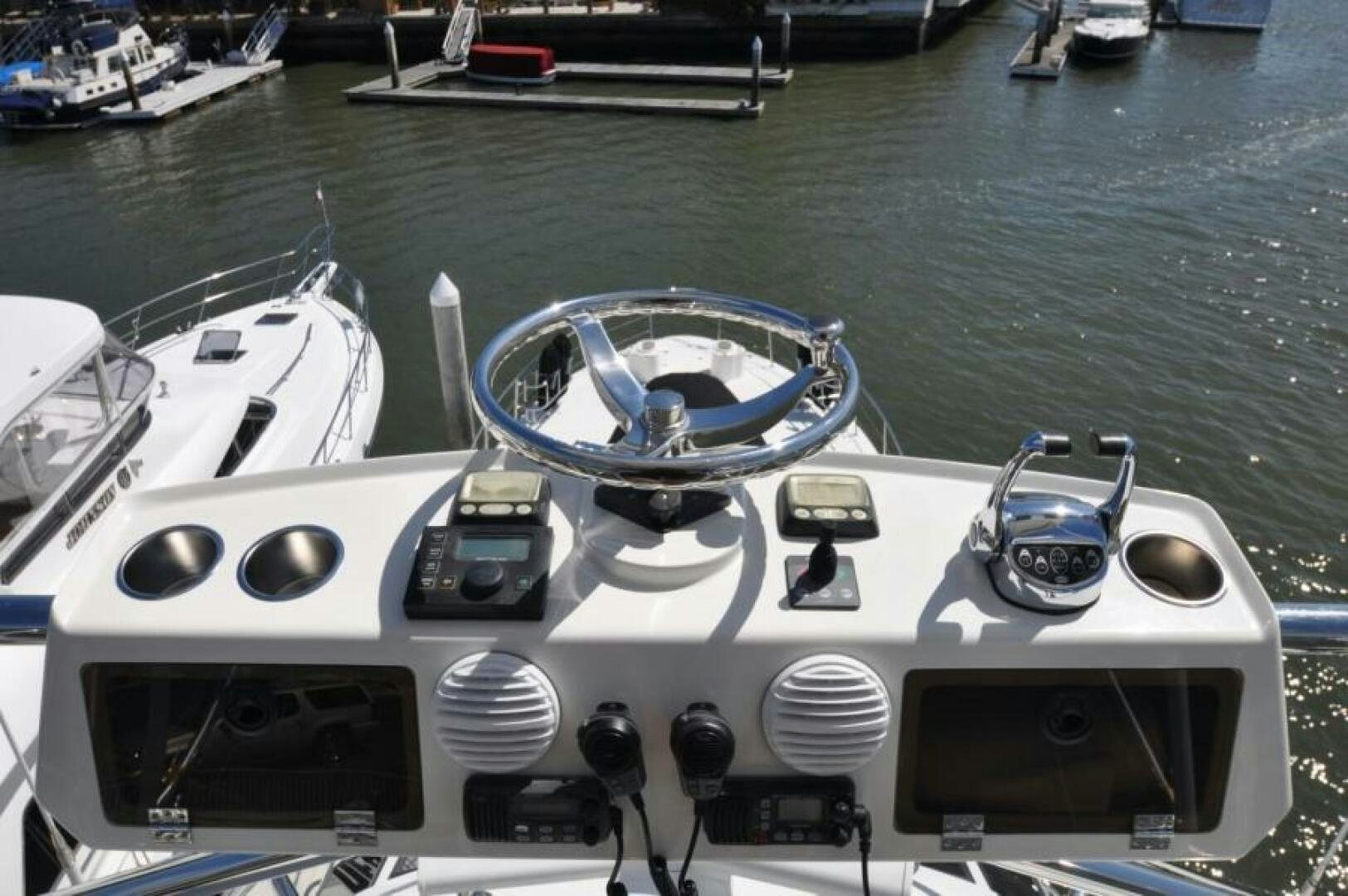 a boat with a steering wheel and other boats in the background aboard FAN TAIL I Yacht for Sale