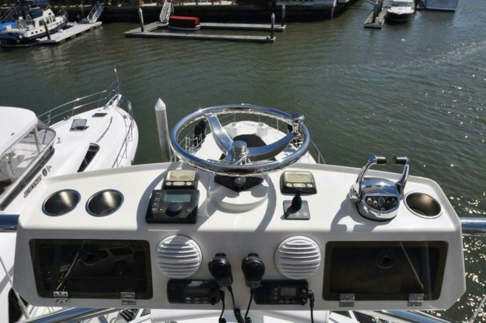 a boat with a steering wheel and other boats in the background aboard FAN TAIL I Yacht for Sale