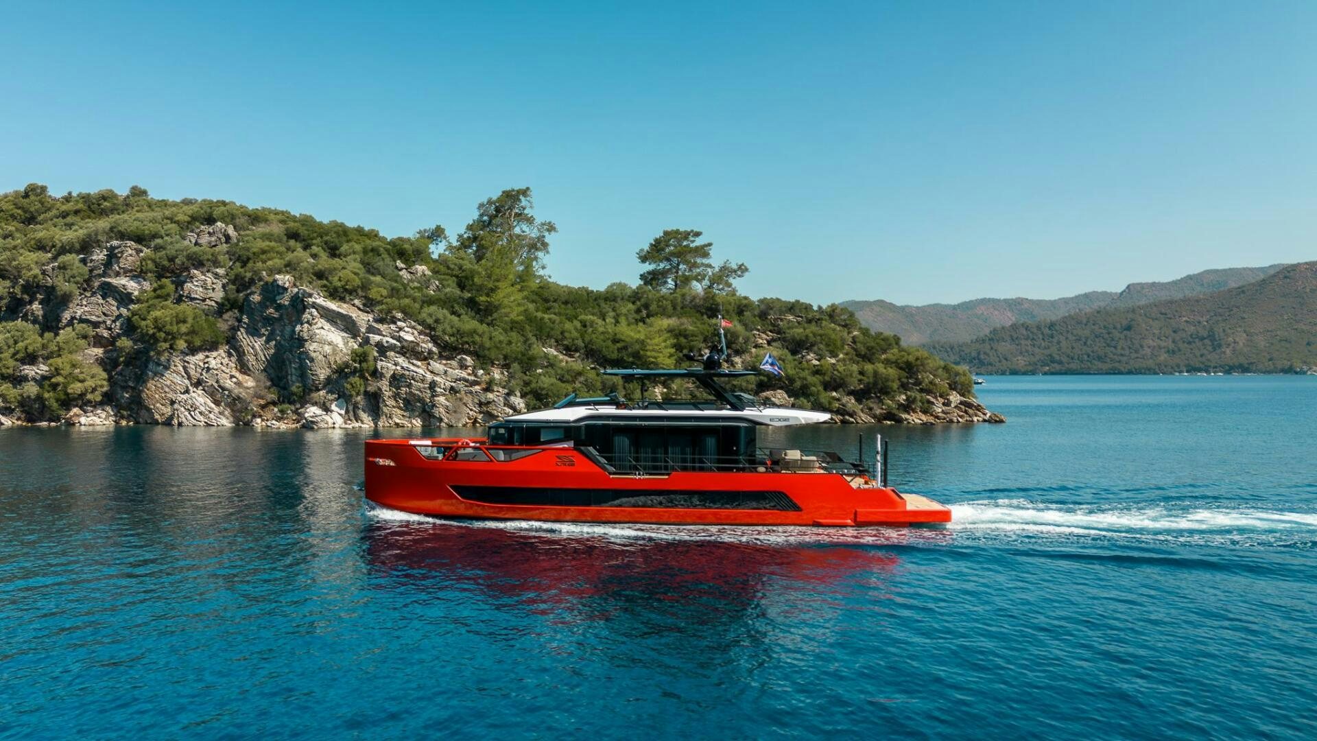 a red boat on the water aboard EDGE Yacht for Sale
